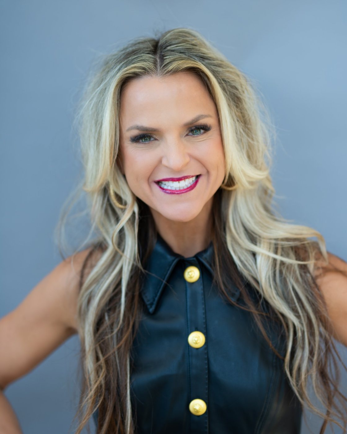 Erika Rothenberger smiling, hands on hips, in a black leather dress