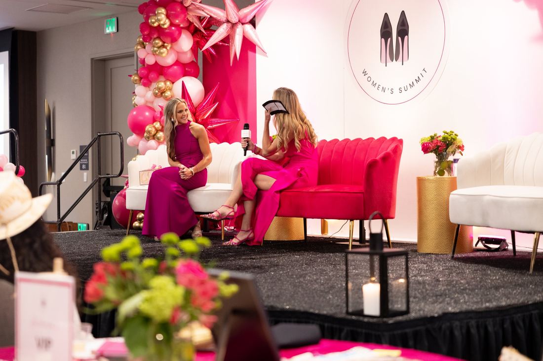 An on-stage conversation on the pink and white Summit stage
