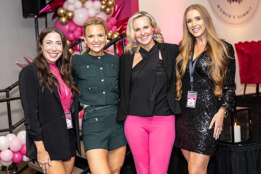 Four women smiling together by the Summit stage