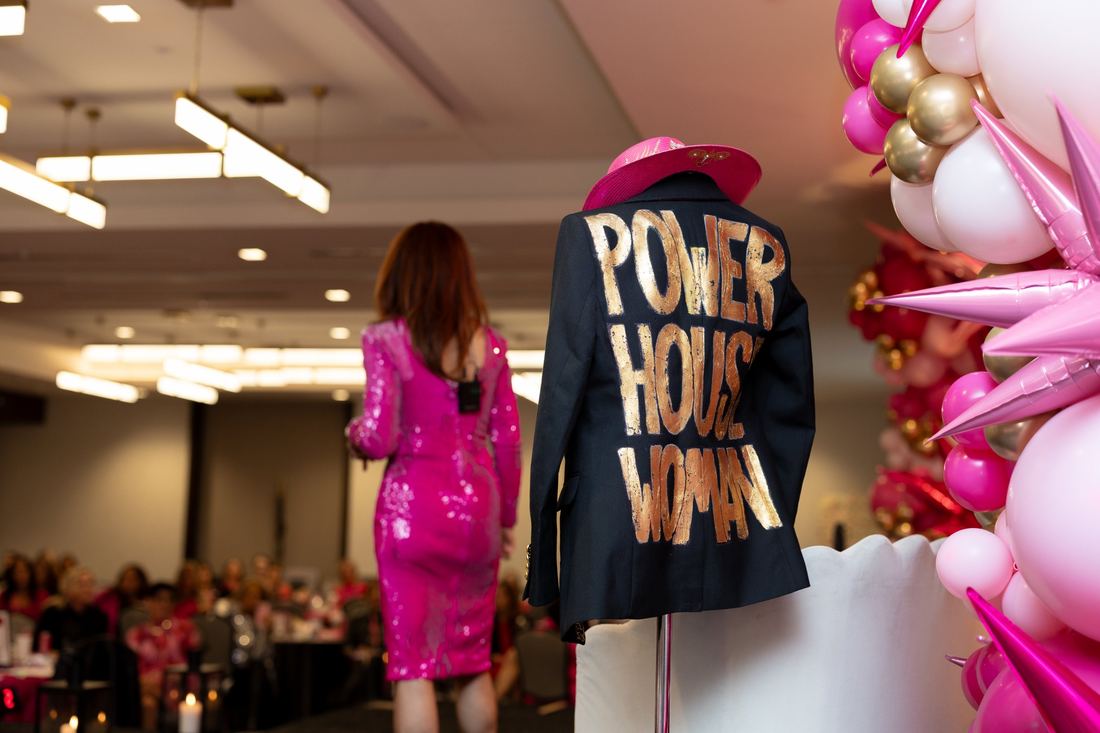 A Power House Woman jacket on display beside the balloon wall