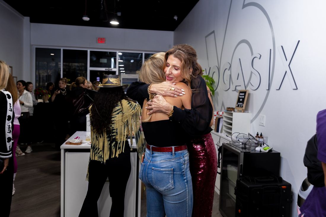 Two women embracing at the YogaSix VIP gathering