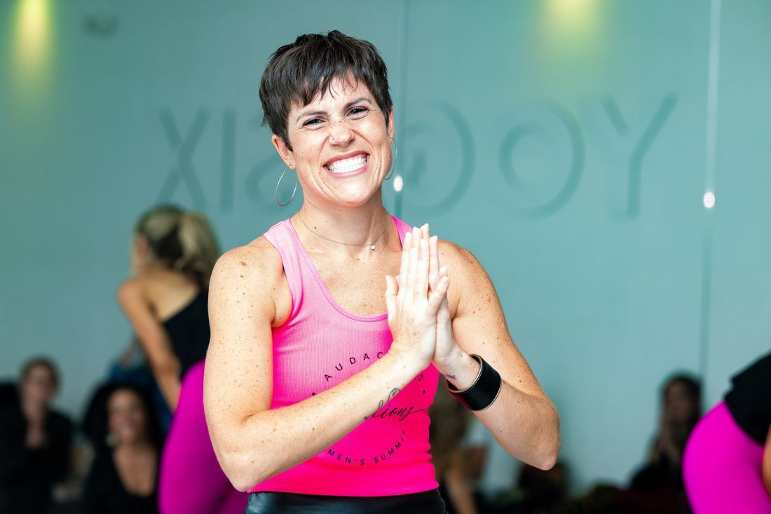A smiling attendee in a pink Summit tank