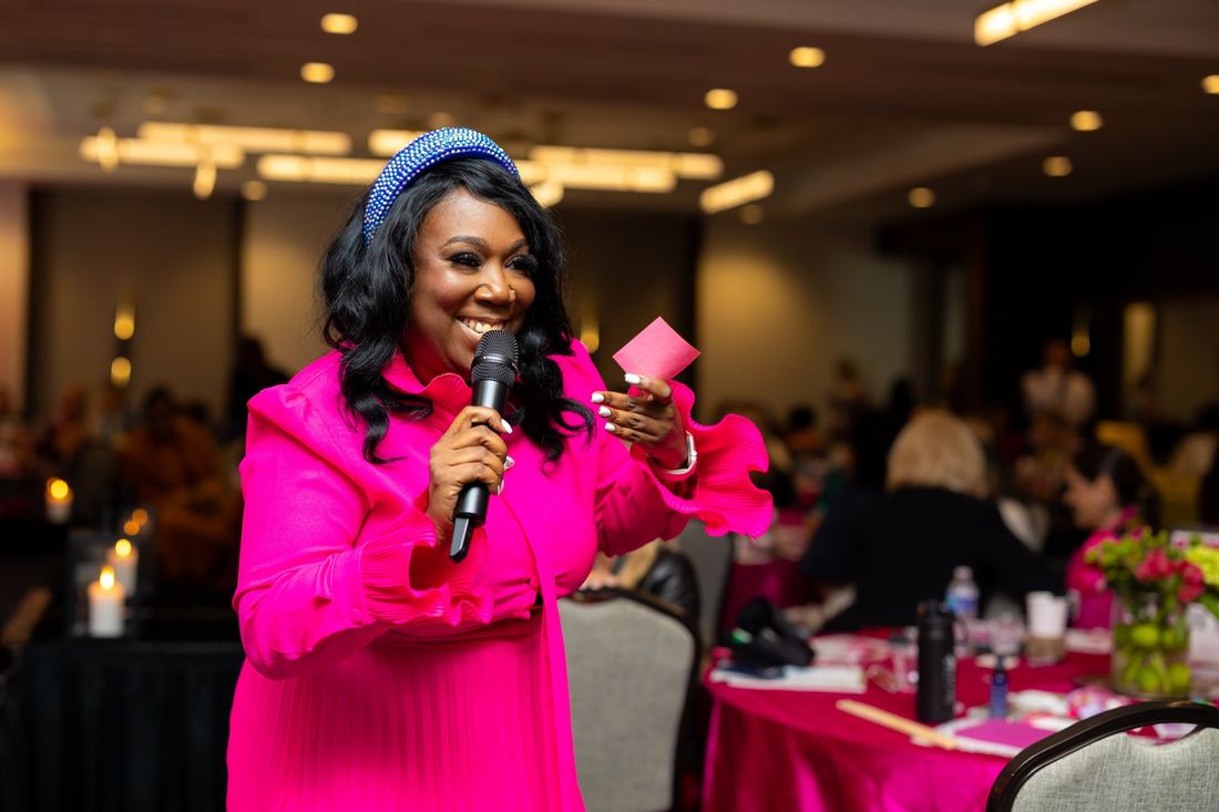 The Summit emcee in pink with a microphone
