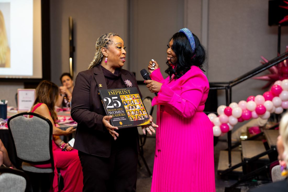 The emcee interviewing an attendee holding IMPRINT